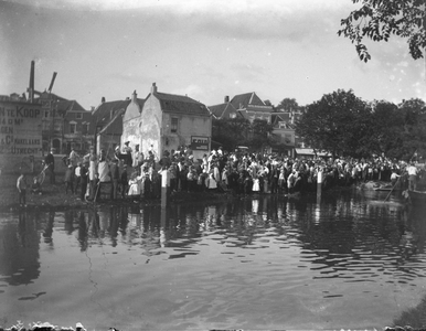 853359 Afbeelding van de toeschouwers langs de oever van de Leidsche Rijn te Utrecht bij het dreggen naar een jongen ...